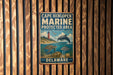 A metal sign with the text "Cape Henlopen Marine protected area" and illustrations of marine life, including a lighthouse, a dolphin, and various sea creatures, is displayed on a wooden wall.