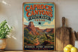 A vintage-style poster of Caprock Canyon, a famous landmark in Texas, is displayed on a wall next to a wooden cutting board and some potted plants.