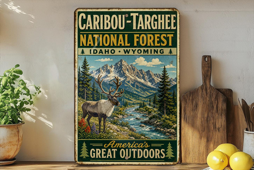 A vintage-style metal sign advertising the Caribbean Targhee National Forest in Idaho, Wyoming, featuring a deer in a mountainous landscape.