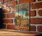 A vintage metal sign with the text "SEVILLA Catedral - Alcazar Archivo de Indias" and "ESPAÑA" is displayed on a brick wall.