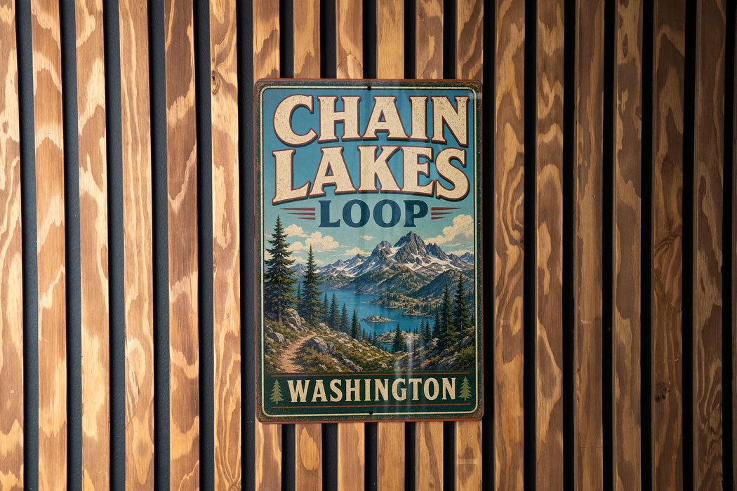 A vintage metal sign for Chain Lakes Loop in Washington, featuring a scenic mountain landscape.