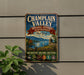 A vintage-style metal sign for the New York National Heritage Partnership, featuring a scenic landscape with mountains, a river, and a castle.