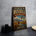 A vintage metal sign for Charles M. Russell's National Wildlife Refuge in Montana, featuring an illustration of wildlife in the background.