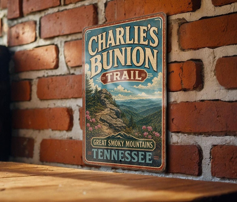 A vintage-style metal sign for Charlie's Bunch Trail in Tennessee, featuring a scenic mountain landscape with pine trees and flowers.