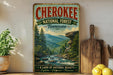 A vintage-style sign for the Cherokee National Forest in Tennessee, featuring a scenic mountain landscape with a river and pine trees.