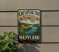 A vintage metal sign for Chesapeake Bay Watershed Cultural Landscape in Maryland, featuring a scenic landscape with a river, boats, and a bird.