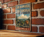 A vintage-style metal sign displaying the text "CHICKAMUGA AND CHATANOOGA NATIONAL MILITARY PARK GEORGIA" is mounted on a brick wall.