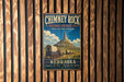 A vintage-style metal sign for Chimney Rock National Historic Site in Nebraska, featuring a wagon train and a mountain in the background.