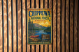 A vintage metal sign for Chippewa National Forest in Minnesota, featuring a scenic landscape with pine forests, a lake, and a canoe.