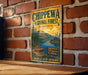 A vintage metal sign for Chippewa National Forest in Minnesota, featuring a scenic illustration of a lake, mountains, and a canoe.