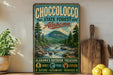 A vintage-style metal sign for Choccolocco State Forest in Alabama, featuring a scenic mountain landscape with a waterfall.