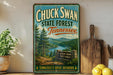 A vintage-style sign for Chuck Swan State Forest in Tennessee, featuring a scenic landscape with pine trees, a river, and mountains.