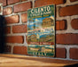 a vintage-style metal sign with illustrations of various landmarks and buildings, including the Colosseum and the Pantheon, set against a brick wall.