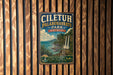 a vintage-style metal sign with a tropical landscape, hanging on a wooden wall.