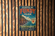 A vintage metal sign for Cliffs of Fundy Park, featuring a scenic image of the park's cliffs and water.