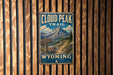A vintage-style metal sign for the Cloud Peak Trail in Wyoming, featuring a mountain landscape and trail marker.