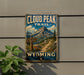 A vintage-style sign for the Cloud Peak Trail in Wyoming, featuring a mountain landscape and trail sign.