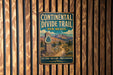 A vintage metal sign for the Continental Divide Trail in New Mexico, featuring a scenic mountain landscape and the trail's name.