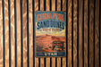 A vintage metal sign for the Coral Pink Sand Dunes State Park in Utah, featuring a desert landscape with mountains in the background.
