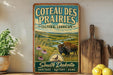 a vintage-style sign for Coteau Des Prairies, a cultural landscape in South Dakota, with a buffalo in the foreground and a scenic landscape in the background.