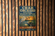 A metal sign for the Crab Orchard National Wildlife Refuge in Illinois, featuring an illustration of a bird and a turtle in a natural setting.