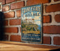 A vintage-style metal sign for Crane Estate at Castle Hill, featuring an illustration of a historic mansion with a scenic coastal view.