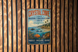 A vintage metal sign for Crystal Cove State Marine Conservation Area in California, featuring an illustration of a coastal landscape with a beach, ocean, and marine life.