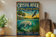 A vintage-style metal sign for the Crystal River National Wildlife Refuge in Florida, featuring an illustration of a manatee swimming in the water.