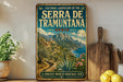 A vintage-style metal sign displaying the text "CULTURAL LANDSCAPE OF SERRA DE TRAMUNTANA SPAIN" with a scenic illustration of a coastal town and mountains.