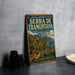 A vintage-style sign for the cultural landscape of the Serra de Tramuntana in Spain, featuring a scenic mountain landscape and a path leading through the area.
