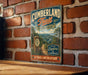 A vintage-style metal sign for the Cumberland Trail in Tennessee, featuring a scenic mountain landscape and the text "A TRAIL LIKE NO OTHER"