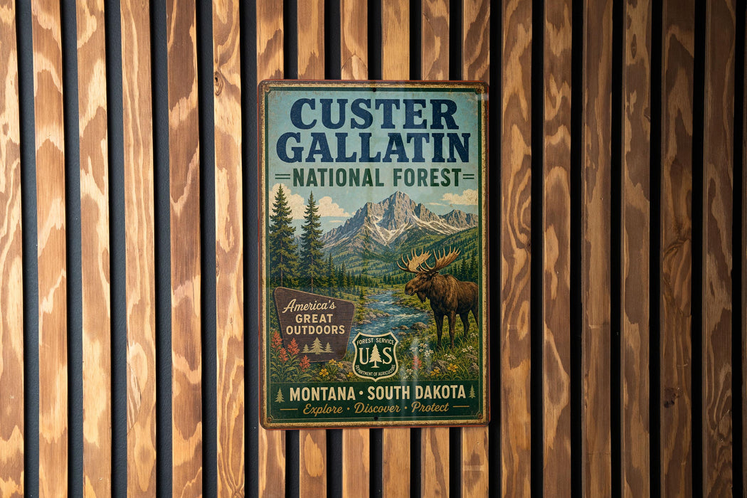 A vintage metal sign for the Custer Gallatin National Forest, featuring a moose and a mountain landscape.