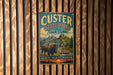 A vintage metal sign for Custer State Park in South Dakota, featuring a buffalo and a scenic landscape.
