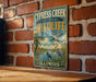 A vintage-style metal sign for the Cypress Creek National Wildlife Refuge in Illinois, featuring an illustration of wildlife in a natural setting.