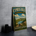 A vintage-style sign for Cypress Hills, an Interprovincial Park in Saskatchewan, Canada, featuring a scenic landscape with a lake and mountains.