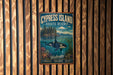 a vintage-style poster of a whale in the water, hanging on a wooden wall.
