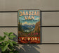 A vintage-style sign for Territorial Park Yukon, featuring a scenic mountain landscape with pine trees and a river.