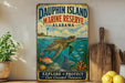 a vintage-style metal sign for Dauphin Island Marine Reserve, Alabama, with a painting of a turtle swimming in the ocean. The sign encourages visitors to explore and protect the coastal treasure.