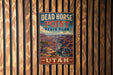 A vintage metal sign for Dead Horse Point State Park in Utah, featuring a scenic image of the Grand Canyon.