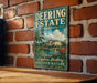 A vintage-style metal sign for Deering Estate, Florida, mounted on a brick wall.