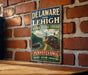 A vintage-style metal sign for the National Heritage Corridor in Pennsylvania, featuring an illustration of a train and a scenic landscape.