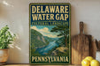 A vintage-style sign for the Delaware Water Gap in Pennsylvania, featuring a scenic landscape with a river and mountains.