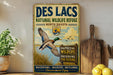 A vintage-style metal sign for the Des Lacs National Wildlife Refuge in North Dakota, featuring a duck in flight and text promoting wildlife conservation and preservation.