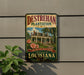A vintage-style sign for the Destrehan Plantation in Louisiana, featuring a house and palm trees, mounted on a wall.