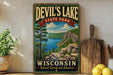 A vintage-style sign for Devil's Lake State Park in Wisconsin, featuring a scenic landscape with a lake, mountains, and pine trees.