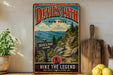 A vintage-style metal sign for Devil's Path, a New York hiking trail, featuring a mountain landscape and trail sign.