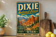 A vintage-style sign for Dixie National Forest in Utah, featuring a scenic illustration of the landscape with mountains and trees.