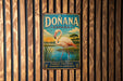 A vintage metal sign with the text "DONANA ESPAÑA" and a flamingo illustration, hanging on a wooden wall.