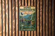 A vintage metal sign with text and illustrations of wildlife, including elephants, a bird, and a monkey, hanging on a wooden wall.