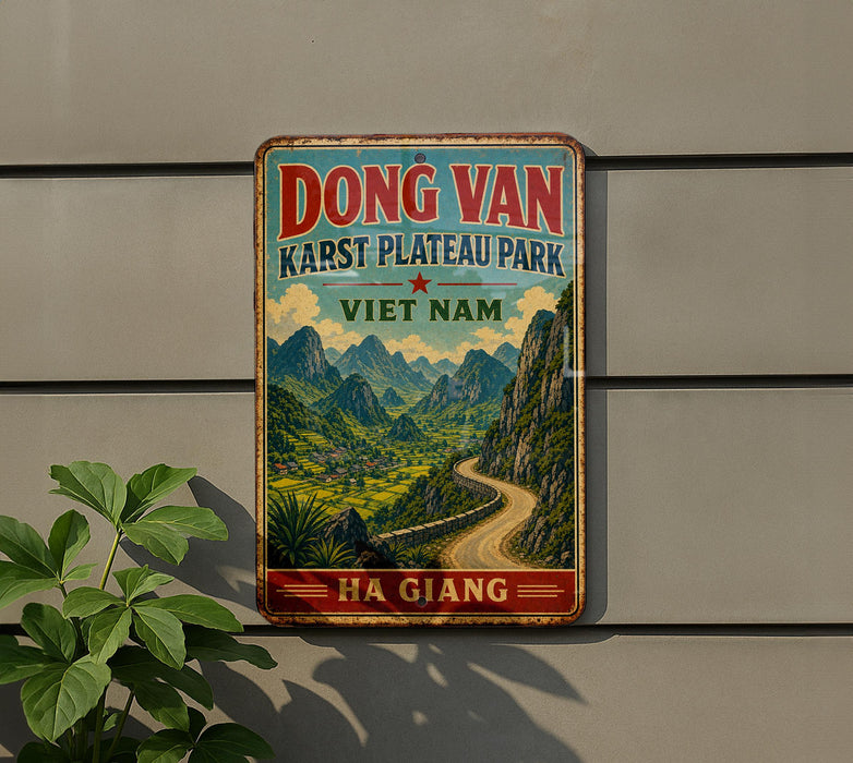A vintage-style metal sign with a scenic mountain landscape and a winding road, mounted on a wall.